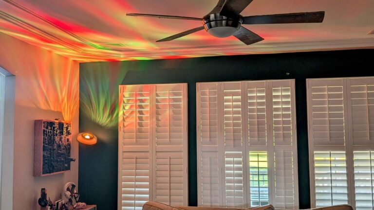 An awesome living room with a Govee uplighter casting red a green ripples across the ceiling