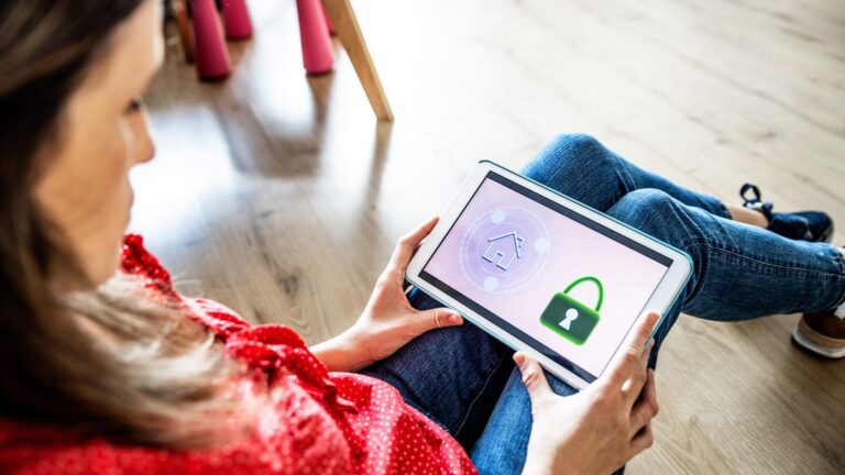 A woman sitting on the floor looking at a screen with home and lock icons.