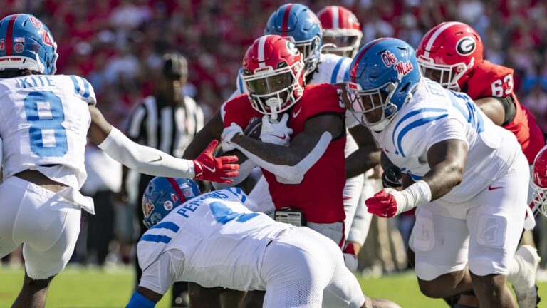 Will Echoles of the Mississippi Rebels tries to wrap up Nate Frazier of the Georgia Bulldogs during a college football game.