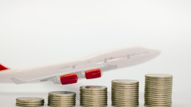 Coins next to airplane model