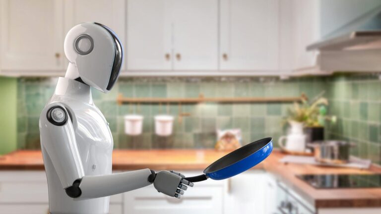 A robot in a kitchen uses a blue frying pan.