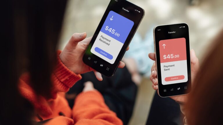 Two people hold phones sending money between apps.
