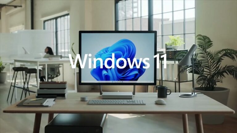 all in one PC on a desk with bright windows behind, overlaid text: Windows 11